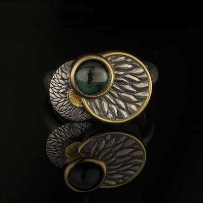 silver and gold ring with green tourmaline and leaf motiff