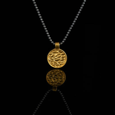 gold plated medal with leaf pattern, black and gold pendant