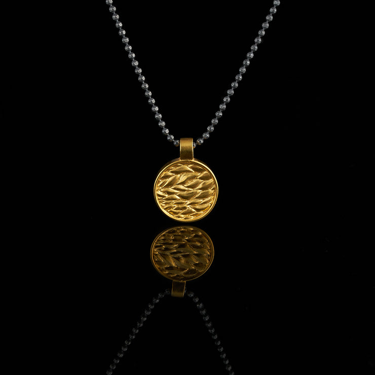 gold plated medal with leaf pattern, black and gold pendant